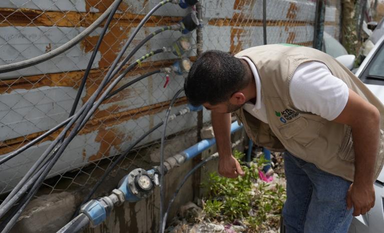 un trabajador de Acción contra el Hambre revisa la red de abastecimiento de agua en tierras de cultivo en el Área C de Cisjordania