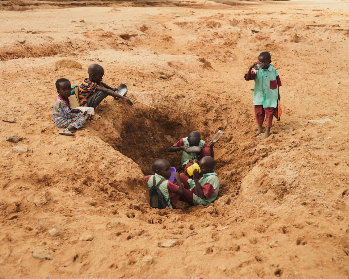Niños de camino a la escuela en Laresoro, Kenia, se detienen a beber y llenar sus botellas. El agua suele estar contaminada con bacterias.