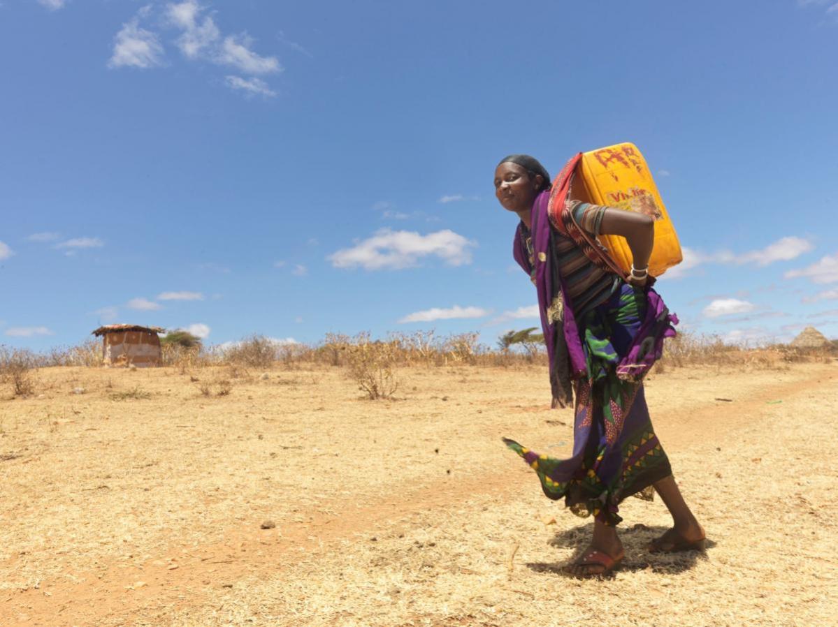 Mujer transportando bidón de agua