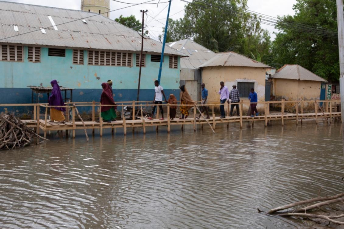 Con las rutas normales al mercado anegadas, los residentes de un pueblo de Somalia utilizan este puente de madera para ir y venir.